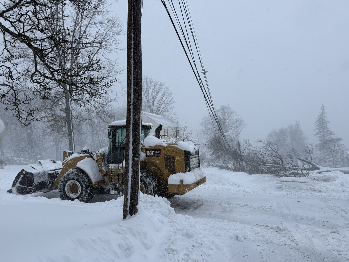CAT 950 wheel loader working in a heavy snowstorm with downed power lines and trees.
