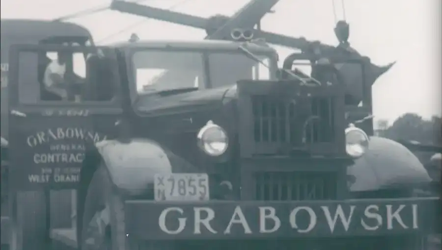 The 1937 GRABOWSKI flatbed truck — plate 7855, painted GENERAL CONTRACTOR · WEST ORANGE on the cab door.