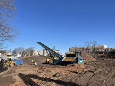 Soil screening conveyor and stockpile mounds on the 110 Washington site.