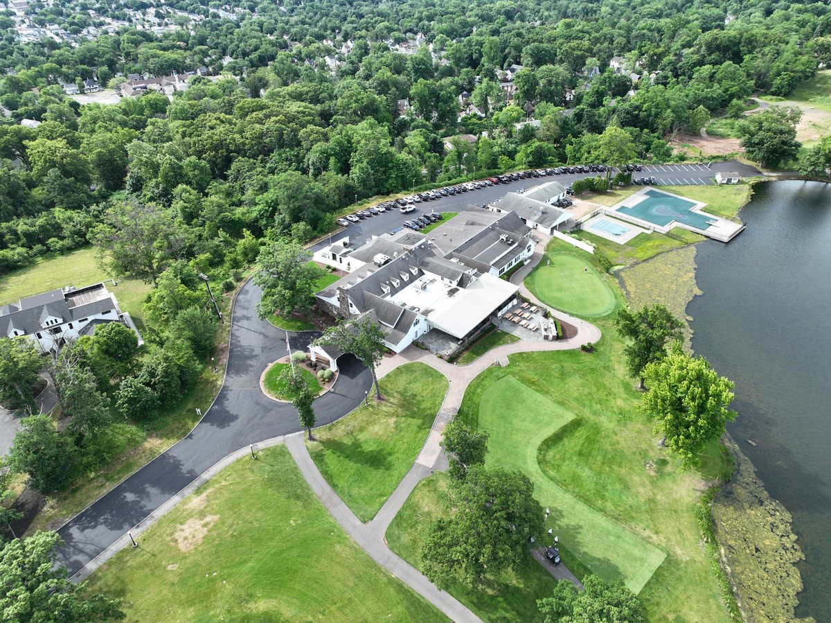 Aerial of Rock Spring Country Club in West Orange, NJ — freshly paved entrance drive and circle leading to the clubhouse by the lake.