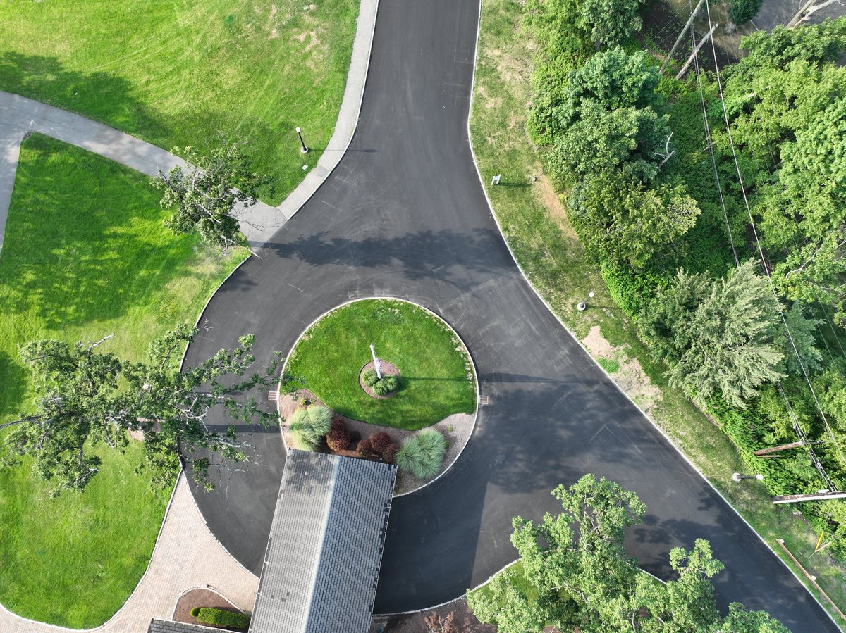 Top-down view of the freshly paved entrance circle in front of the clubhouse porte-cochère.