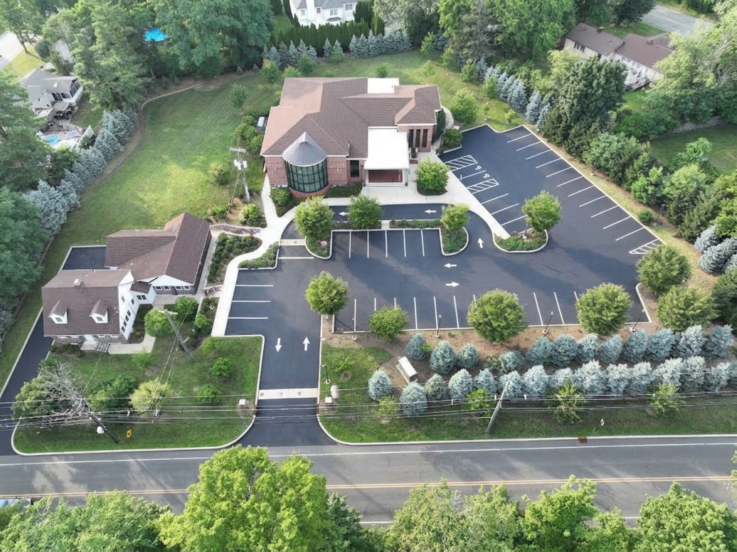 Aerial of the completed Shirdi Sai Hira Hindu Temple with its new paved parking lot, drive aisles, and landscaped islands.