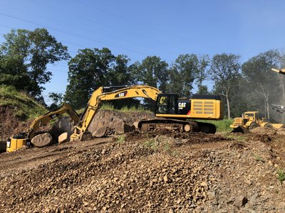 Cat 349F excavator and dozer working a rock cut on hillside terrain