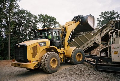 Cat 950 wheel loader dumps rock into Metso crushing plant feed hopper