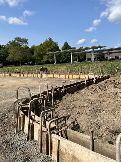 Close view of curb formwork with rebar tie supports awaiting concrete placement