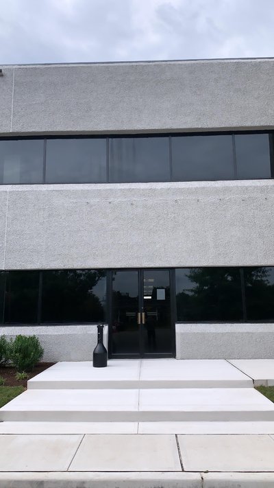 Concrete entrance steps and landing leading to glass double doors of commercial building